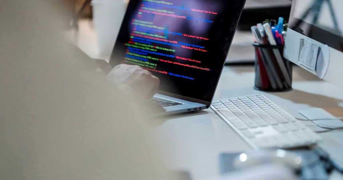 Ordinateur portable affichant du code sur un bureau pour illustrer une IA exécutée localement